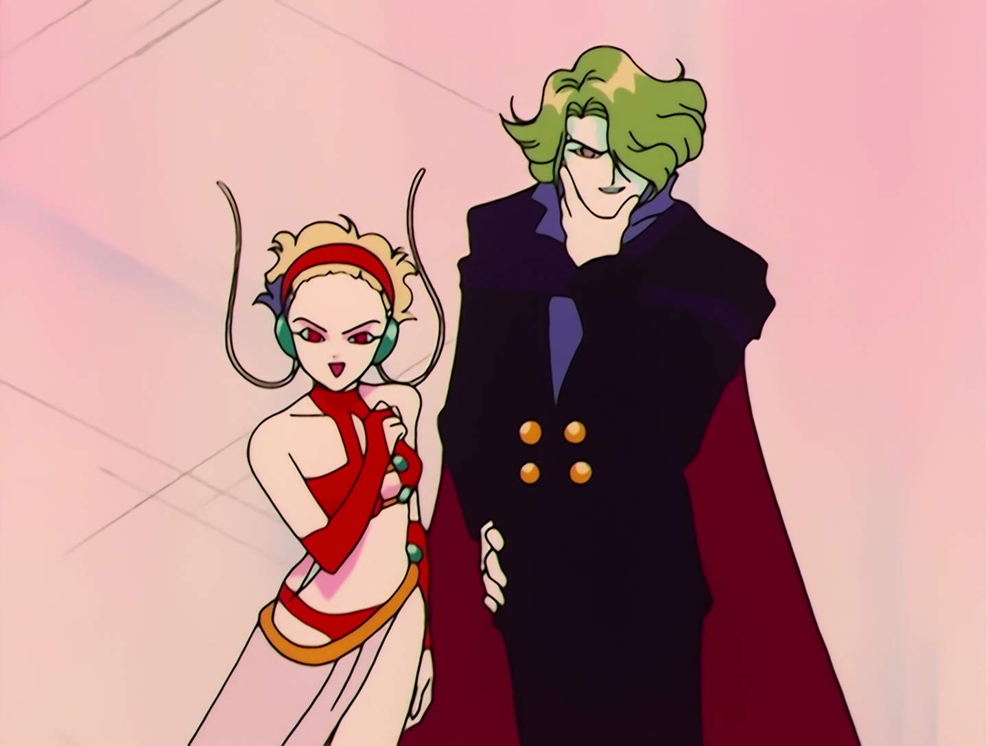 Janelyn and Misha, aka Zoyrin Geller, Youma from Sailor Moon episode 39. We have Janelyn, the woman, on the left, and Misha, the man, on the right. They both have pale white skin. Janelyn has short blonde hair, and her outfit consists of a red top, headband, gloves and bottoms, with a white skirt worn asymmetrically. She also has green things over her ears with twisty antennae coming off them. Misha has long green hair, and wears a black tuxedo with a red cape.